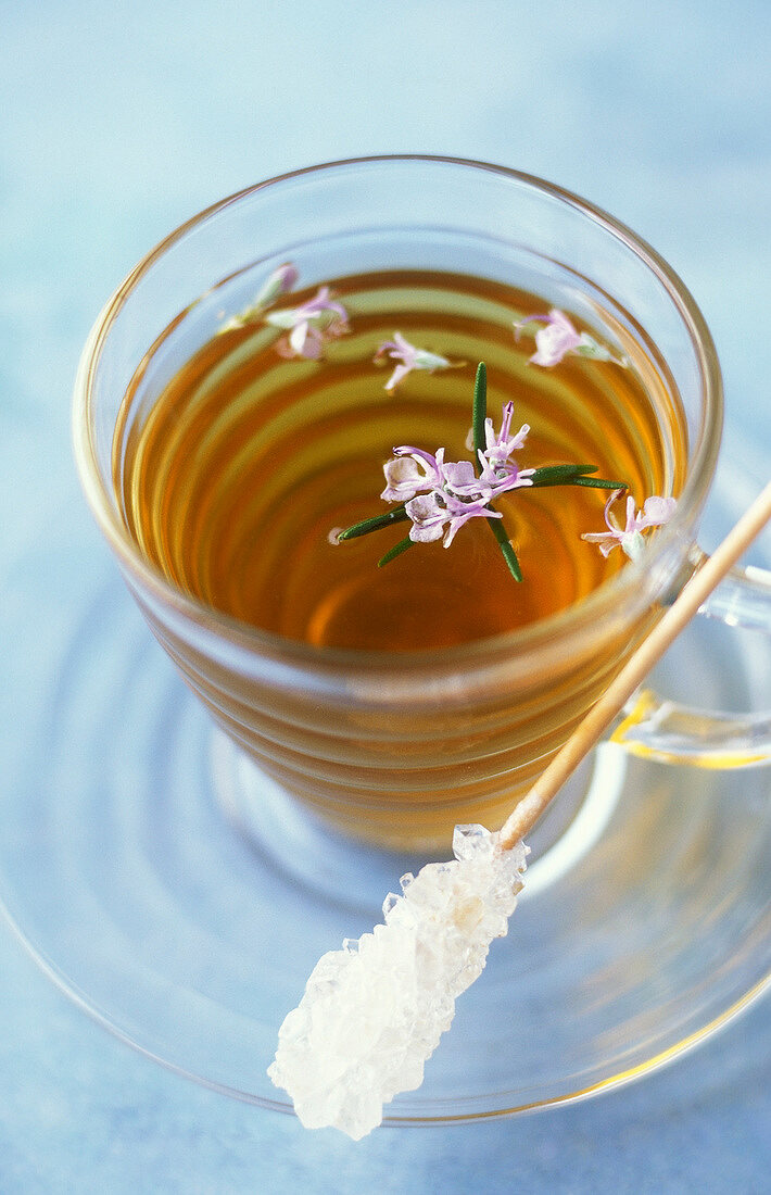 Tasse Kräutertee mit Rosmarin und Blüten