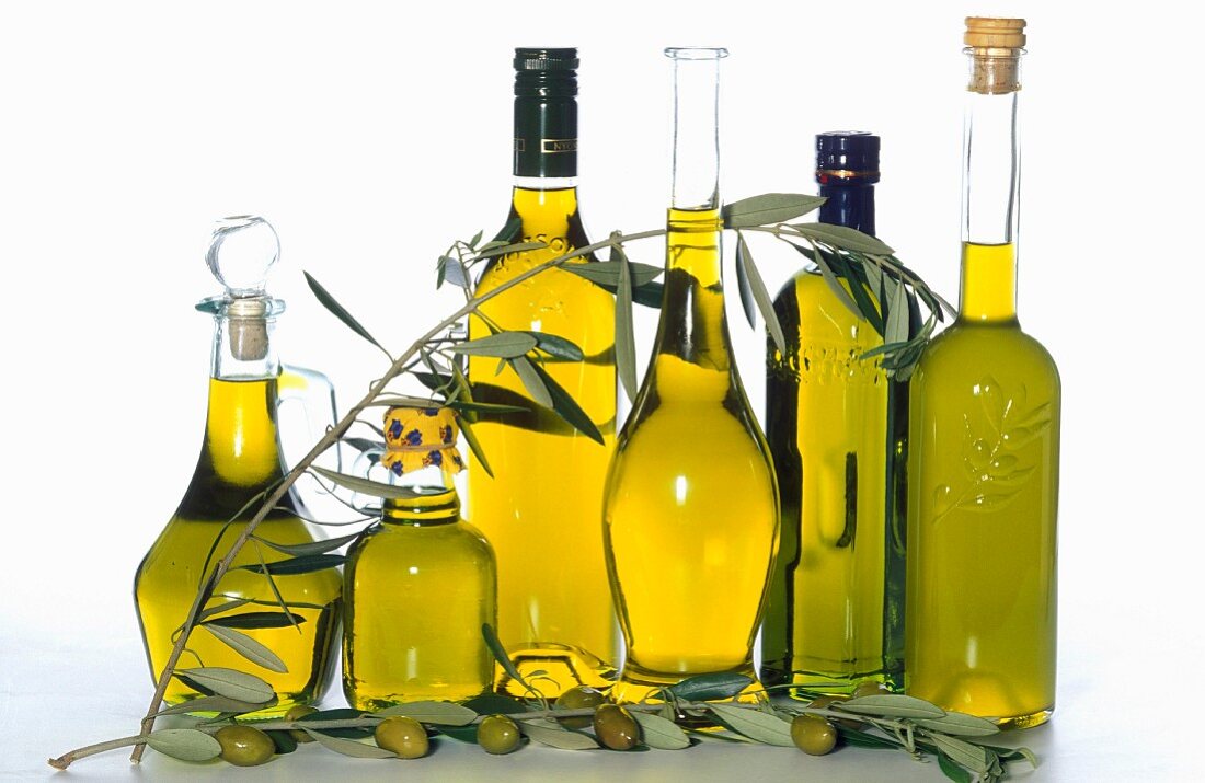 Verschieden Flaschen Olivenöl mit Olivenzweig