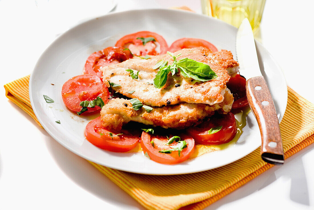 Breaded turkey escalopes with tomatoes and basil