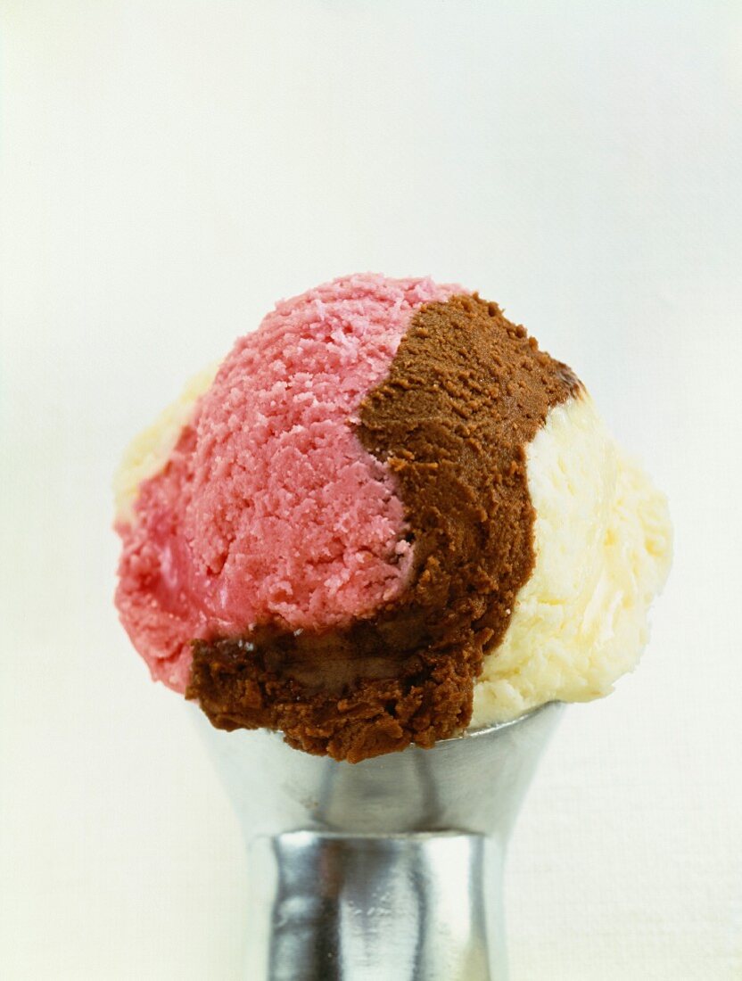 Dreifarbige Eiskugel aus Vanille-, Erdbeer- und Schokoladeneis