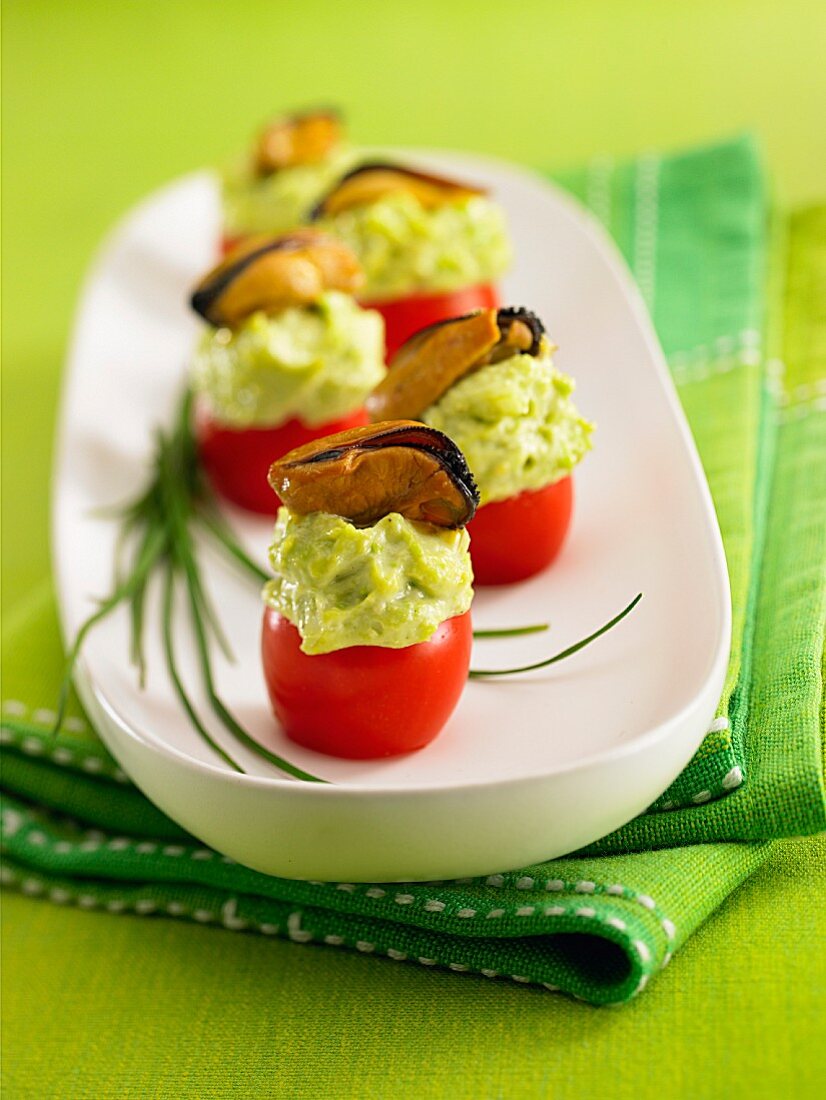 Stuffed cherry tomatoes with green mayonnaise and mussels