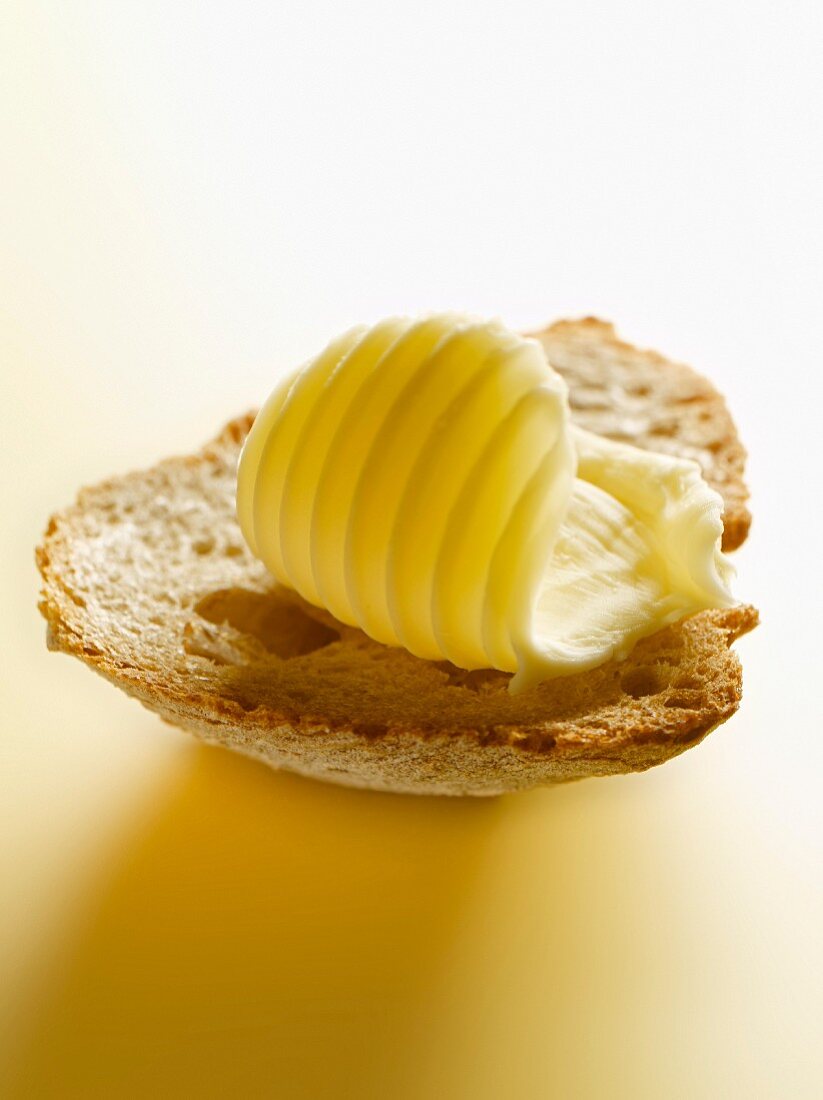 Ein Stück Butter auf einer Scheibe Brot