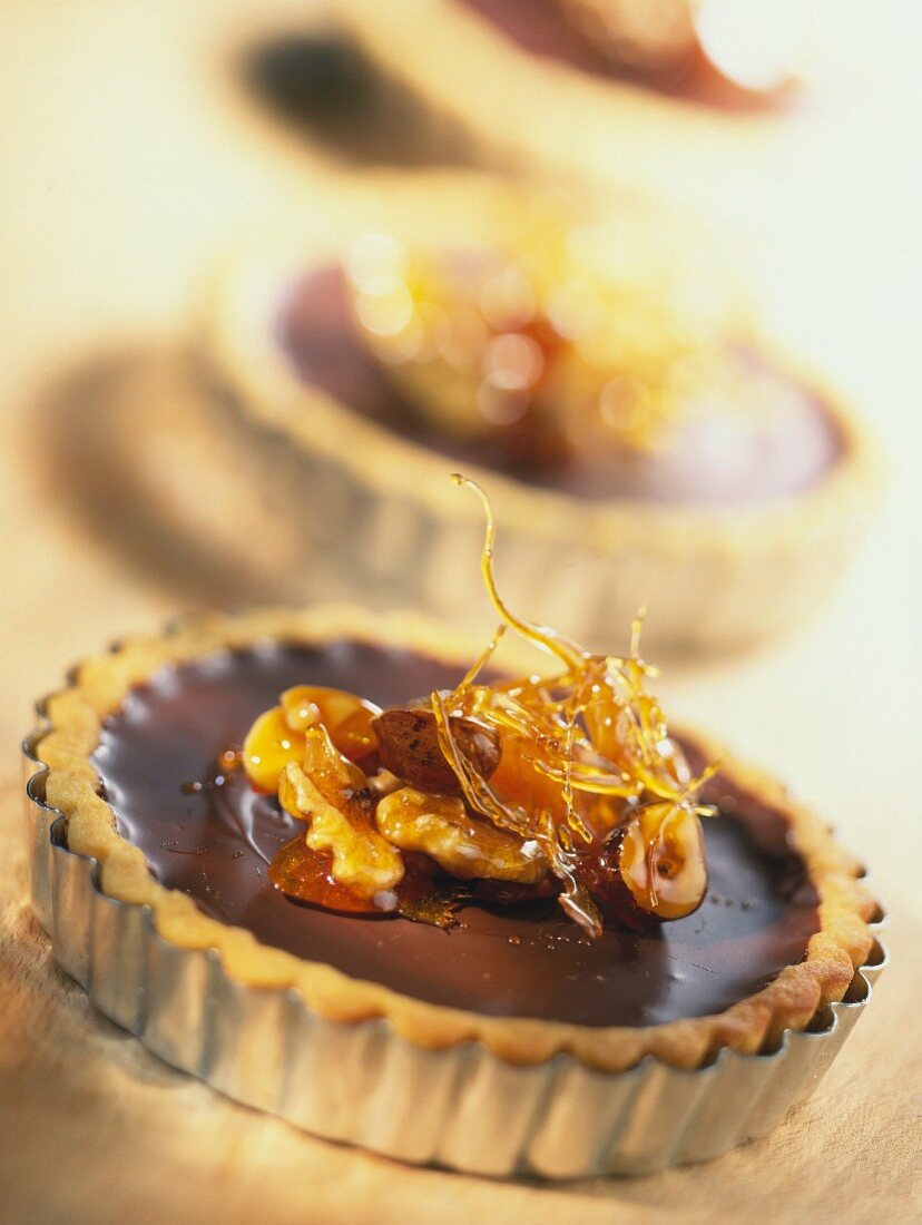 Chocolate tarts with dried fruit, nuts and caramel