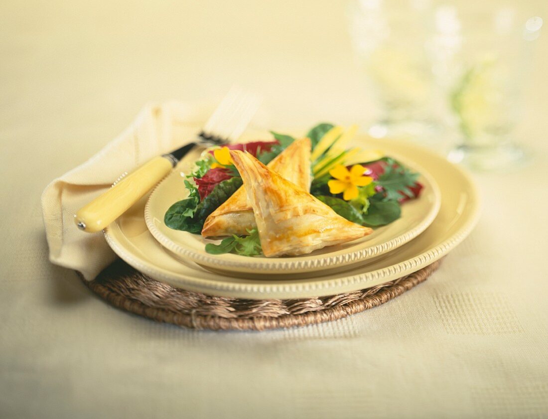 Gefüllte Blätterteigtäschchen auf Salat