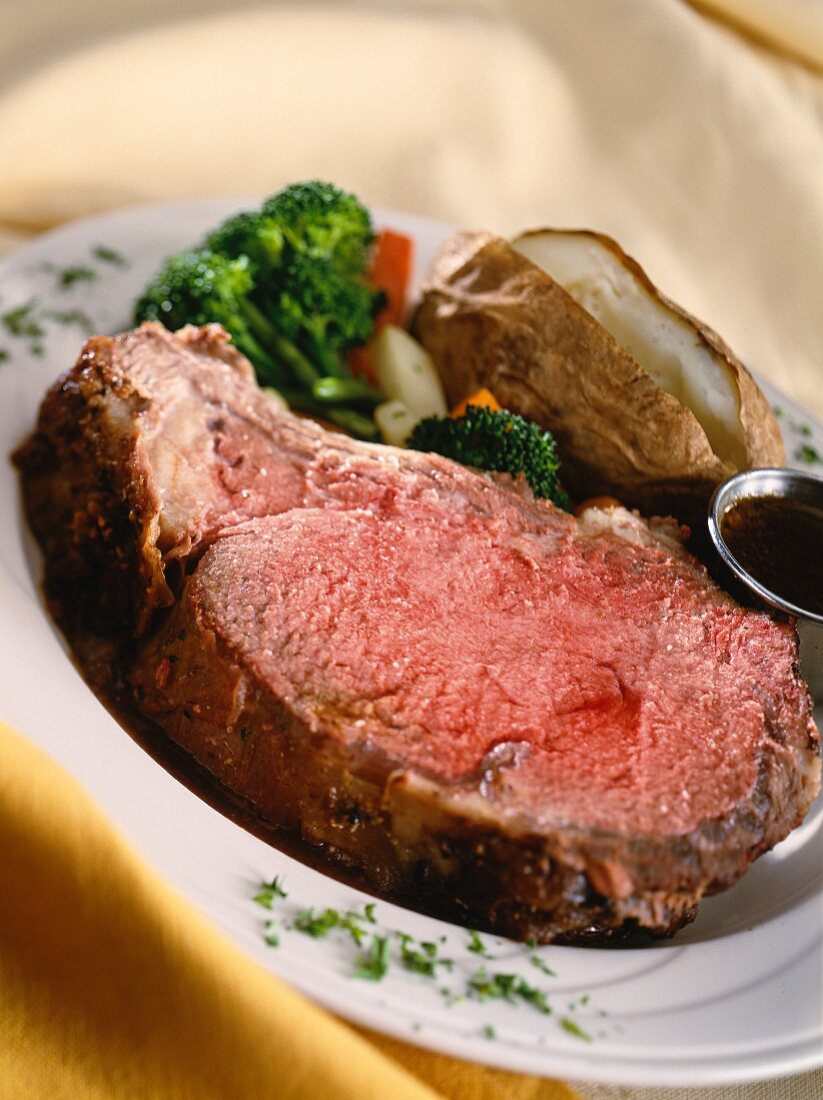 A Whole Chuck Roast, Partially Sliced on a Platter with Veggies