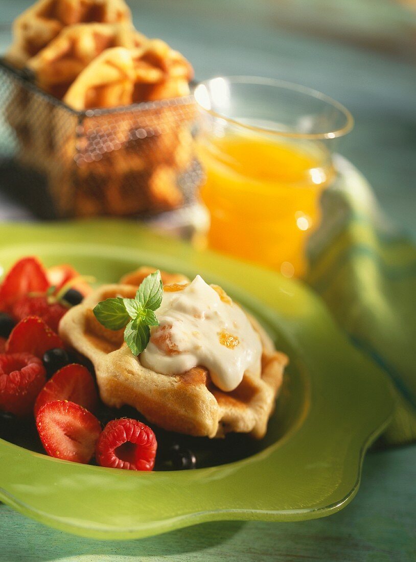 Waffles with orange cream on red berries