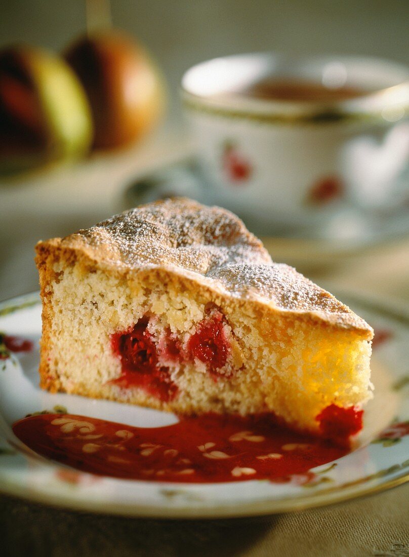 A slice of cherry sponge cake with cherry sauce