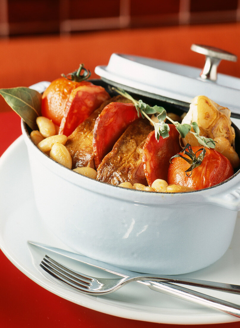 Casserole dish of roast veal with tomatoes and white beans