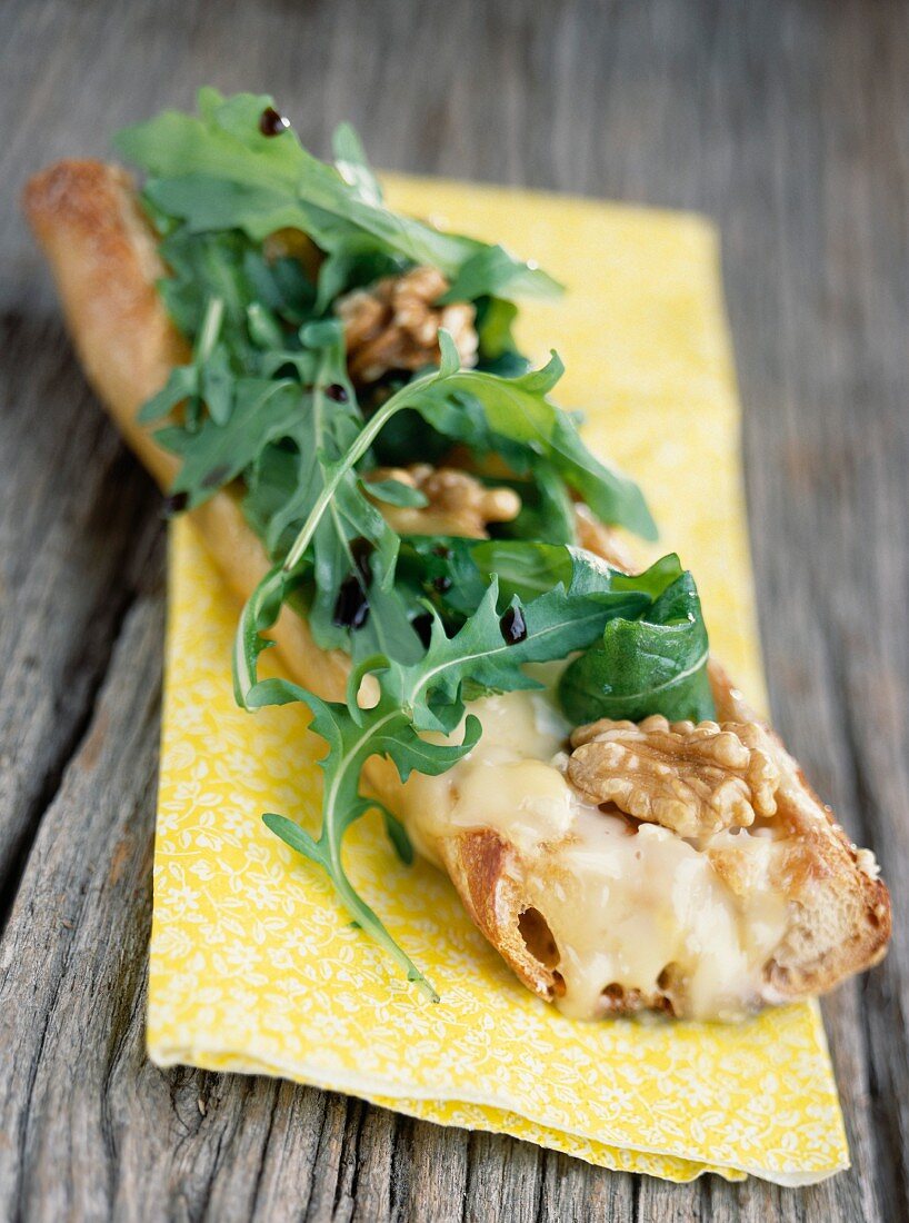 Belegtes Brot mit Brie, gehackten Walnüssen und Rucola