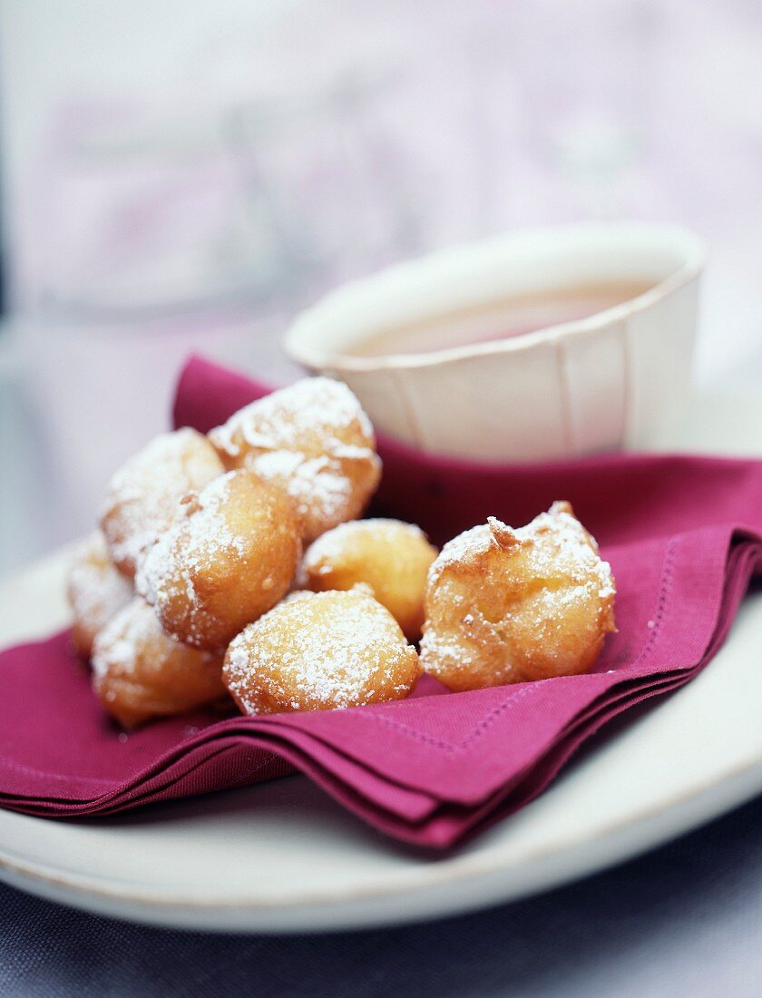 Beignets mit Puderzucker und Schale heiße Schokolade