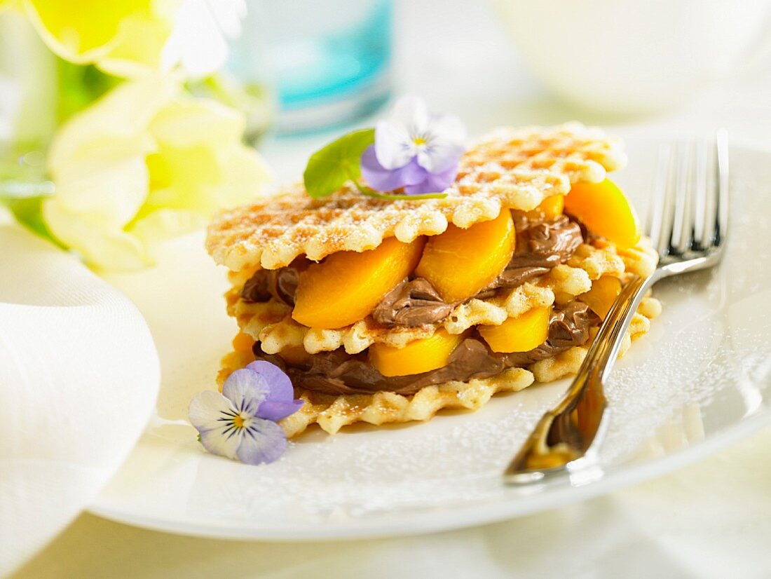 Waffles layered with chocolate mousse and peaches
