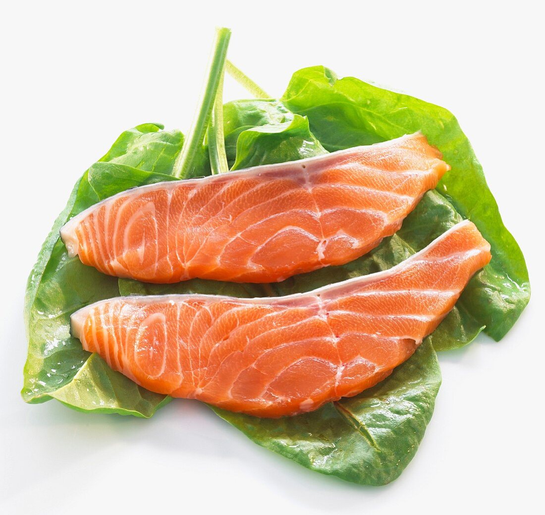 Raw salmon fillets with fresh spinach
