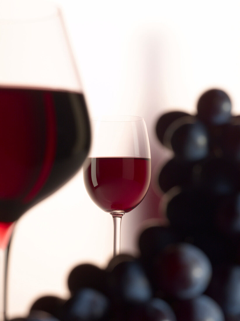 Rotweingläser und blaue Weintrauben