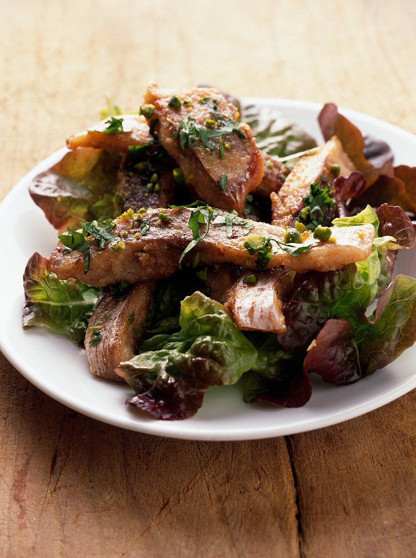 Gebratene Karpfenstücke auf Salat mit Pistazien