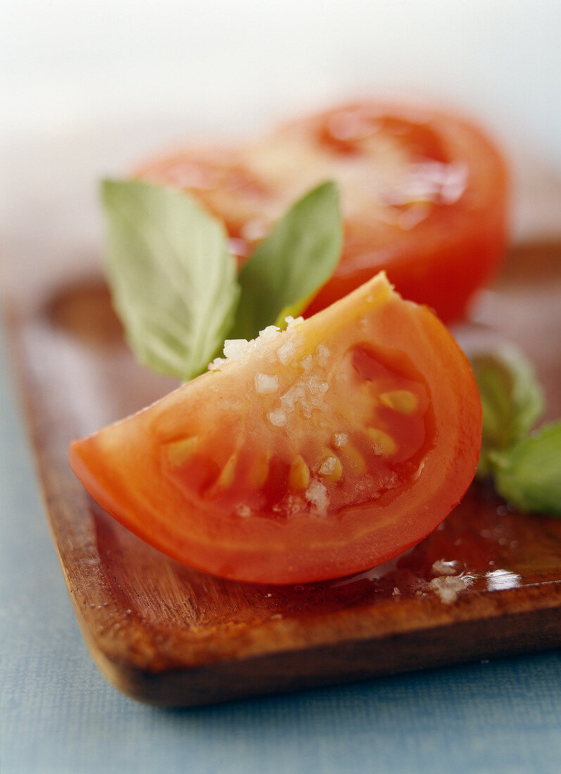 Tomatenstücke mit Salz auf Schneidebrett