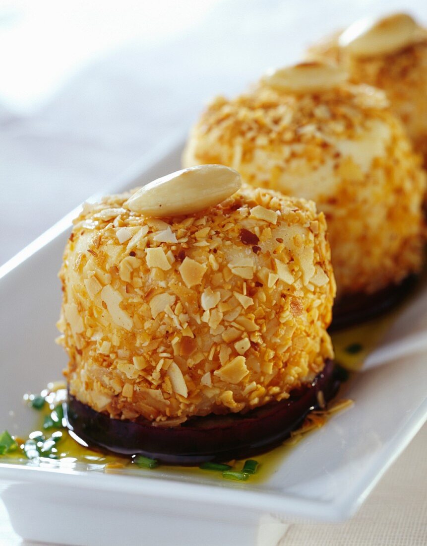 Goat's cheese coated in crushed almonds and stewed eggplants
