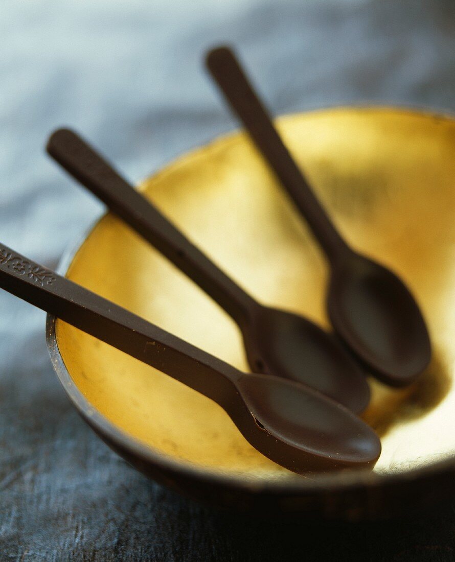 Three chocolate spoons on a dish