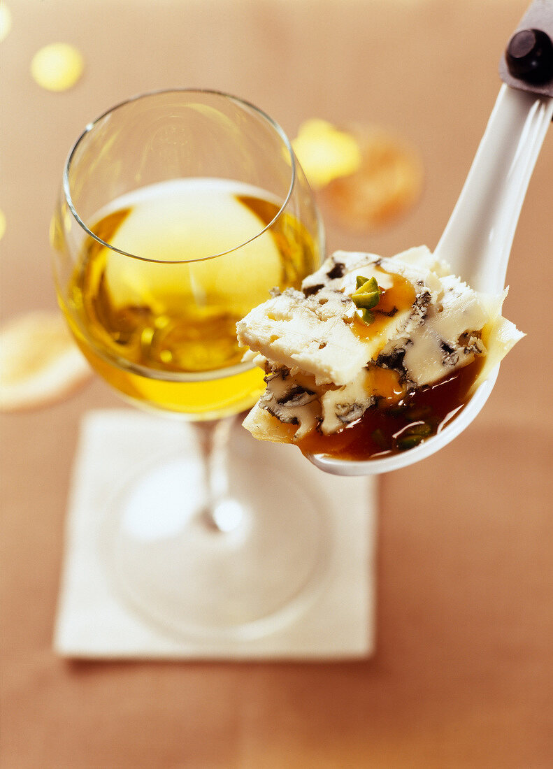 Löffel-Happen mit Roquefort, Pistazien, Parmesan und Aprikosensauce, dazu ein Glas Weißwein