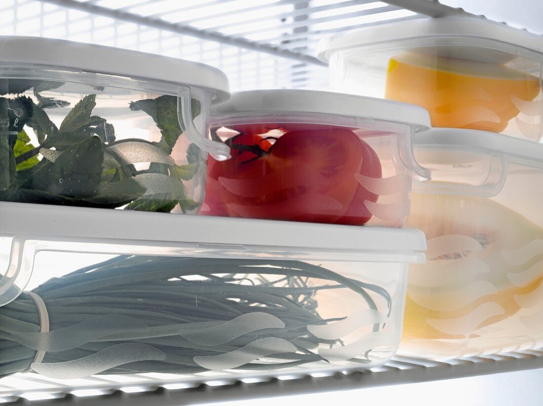 Tupperwares full of fresh products in the refrigerator