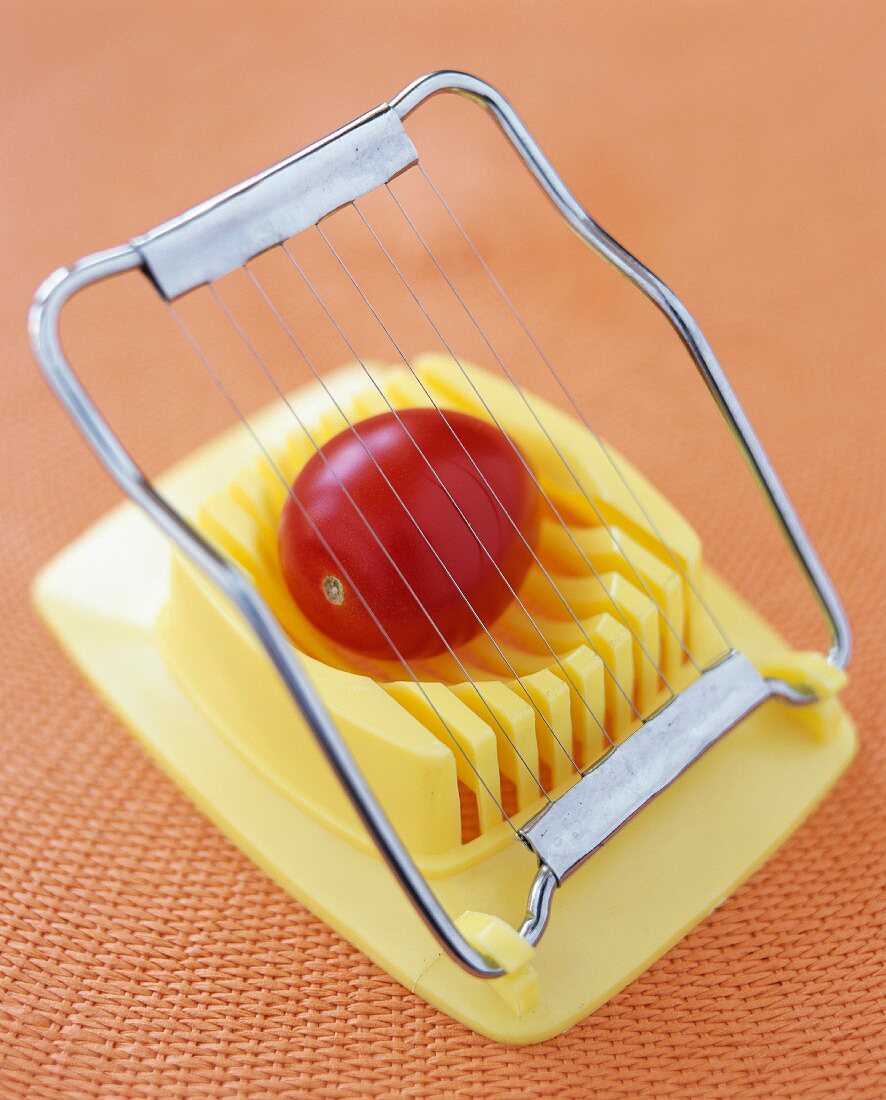 A tomato on an egg slicer