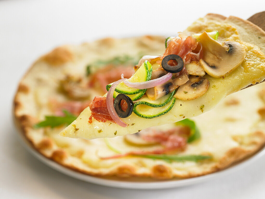 Pizza mit Champignons, Zucchini, Rohschinken und Oliven