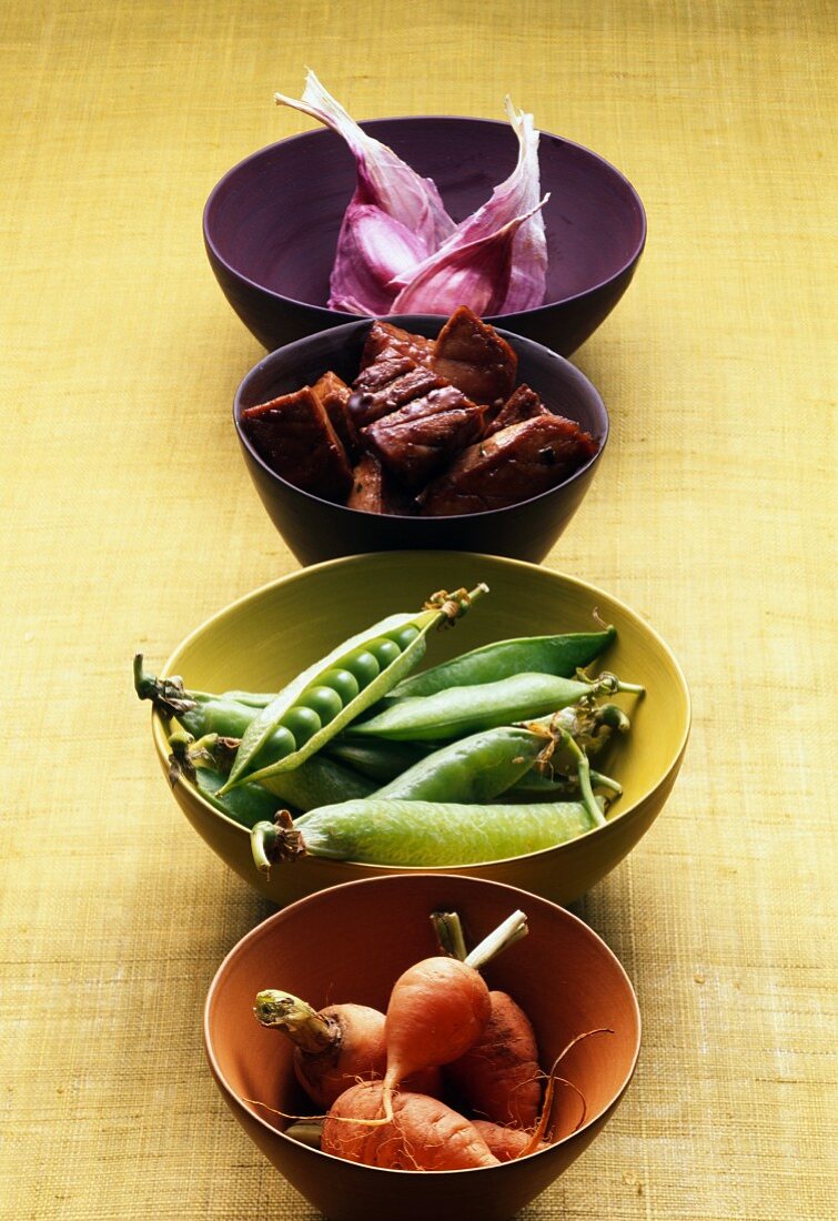Bowls of carrots,peas,garlic and tuna