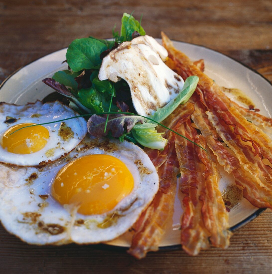 Fried eggs with bacon and a mushroom salad