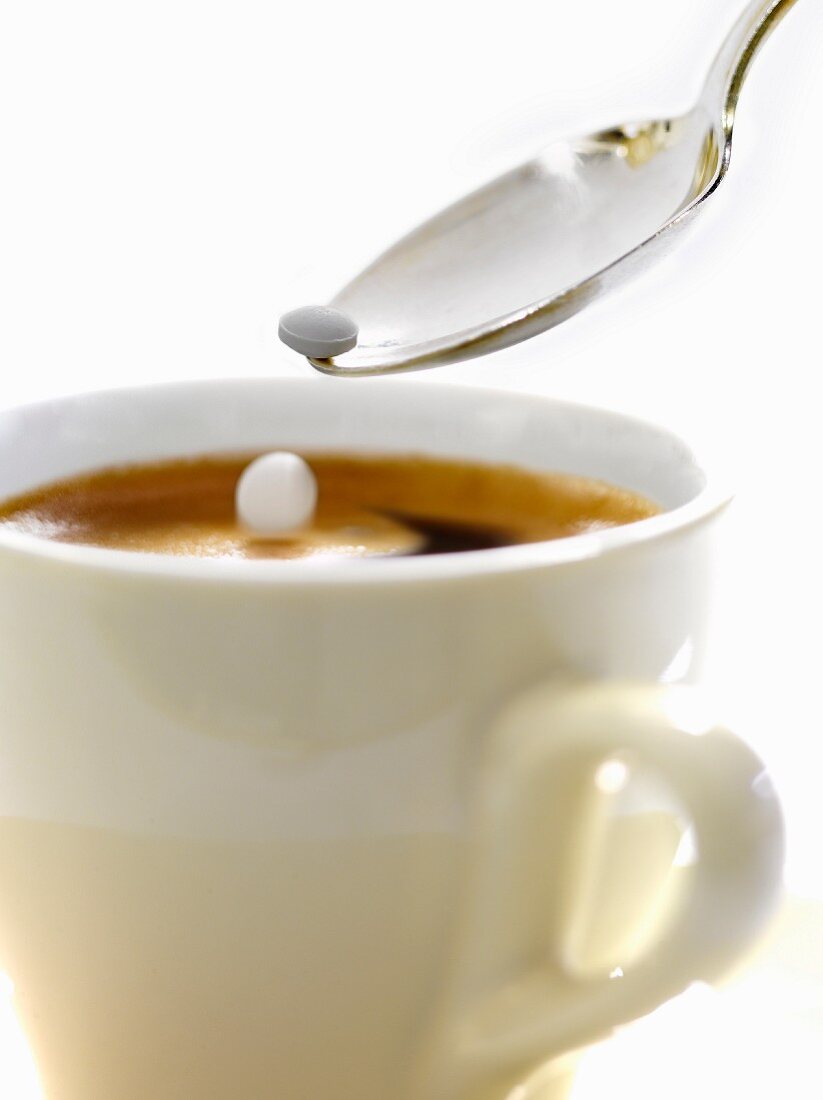 Zwei Süssstofftabletten fallen in eine Tasse Kaffee