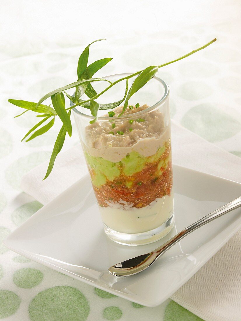 Tuna fish mousse, peas, tomatoes and cream in a glass