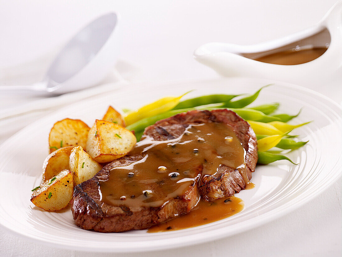 Steak with pepper sauce ,beans and potatoes