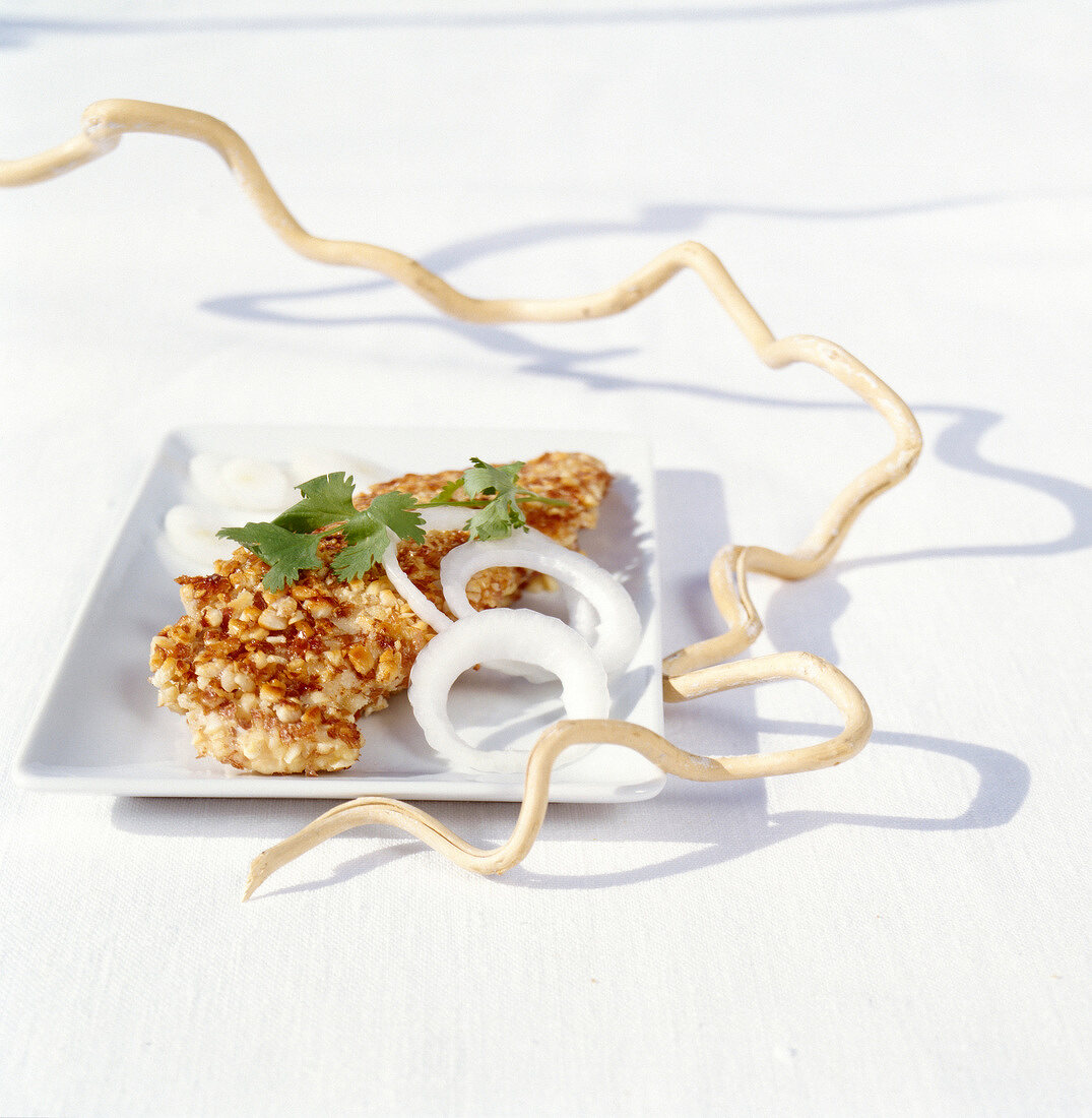 Fried chicken breasts coated with crushed peanuts
