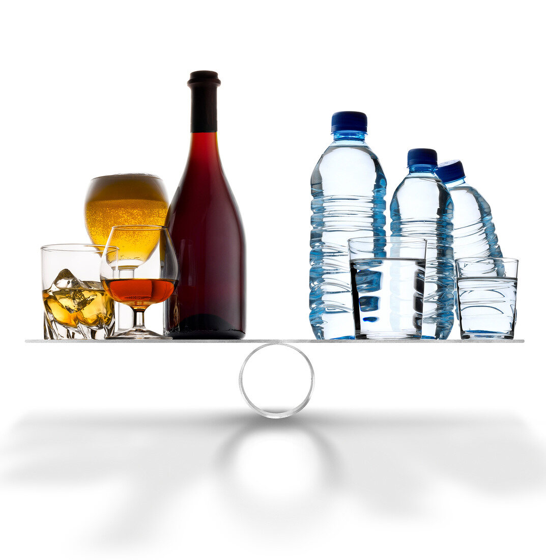 Alcoholic drinks against water on scales