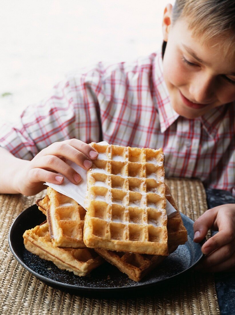 Kind hält eine Waffel mit Zucker