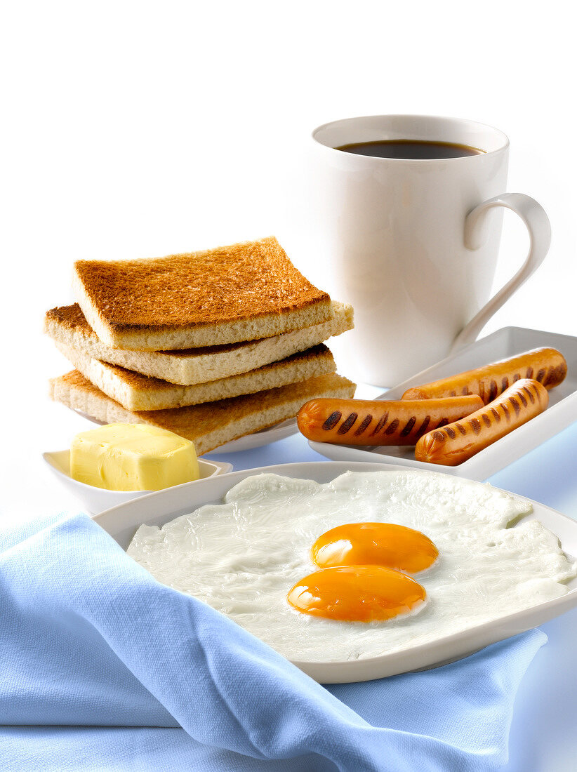 Amerikanisches Frühstück mit Spiegelei, Würstchen, Toast und Kaffee