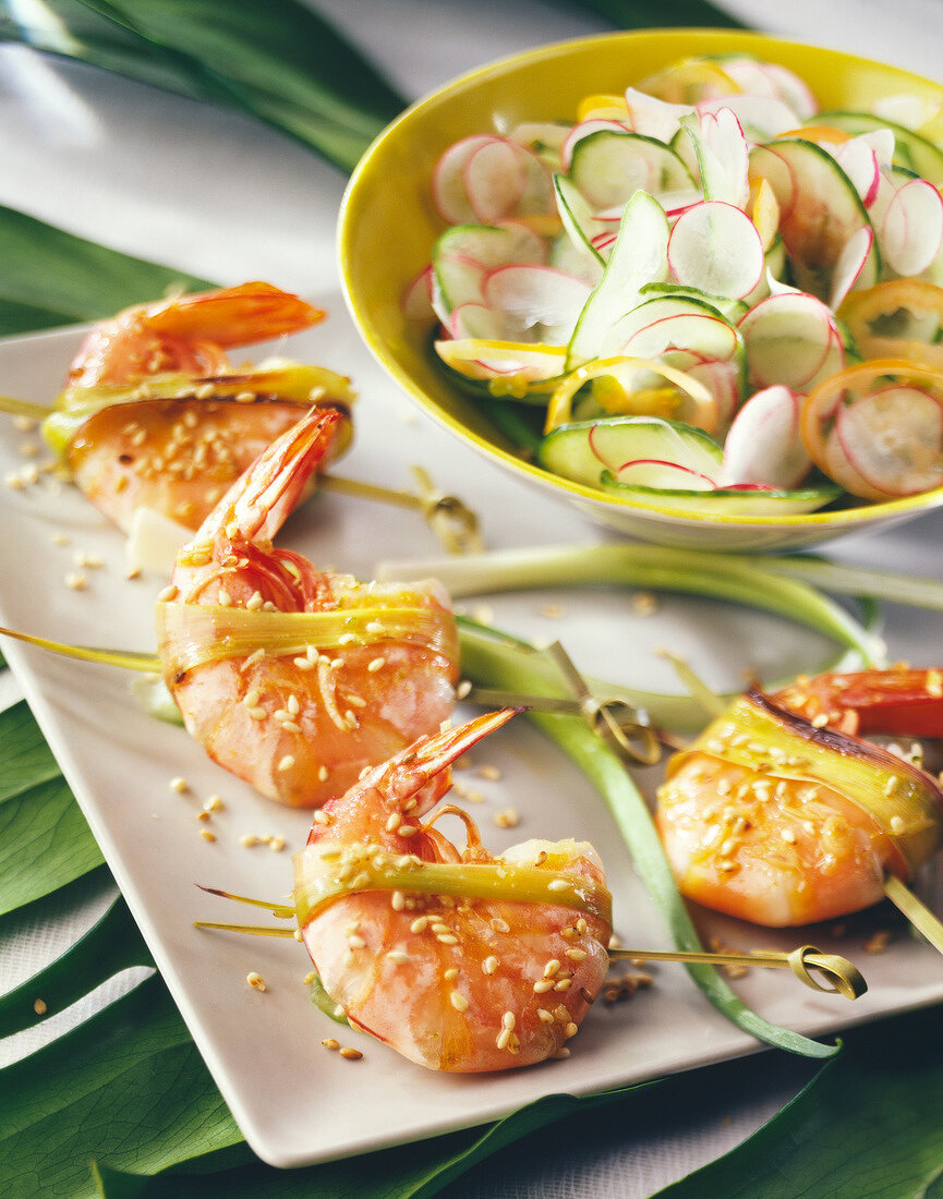 Shrimp kebabs with sesame seeds and cucumber and radish salad