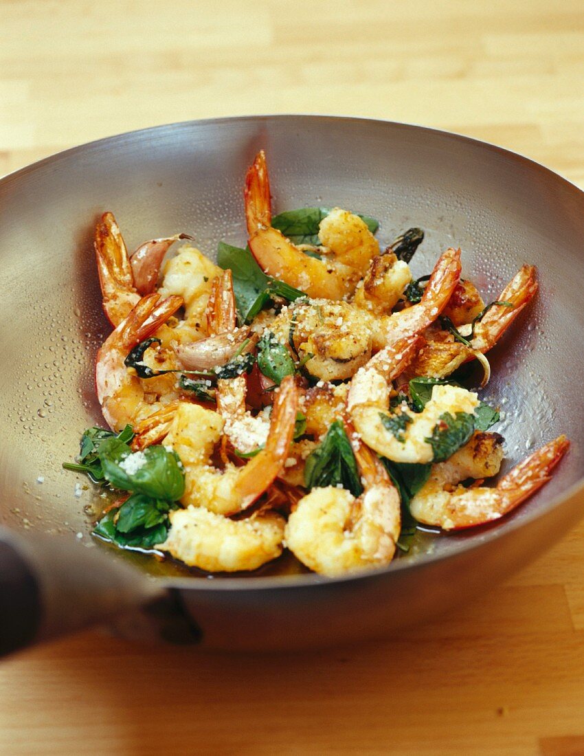 Gambas and basil cooking in a wok