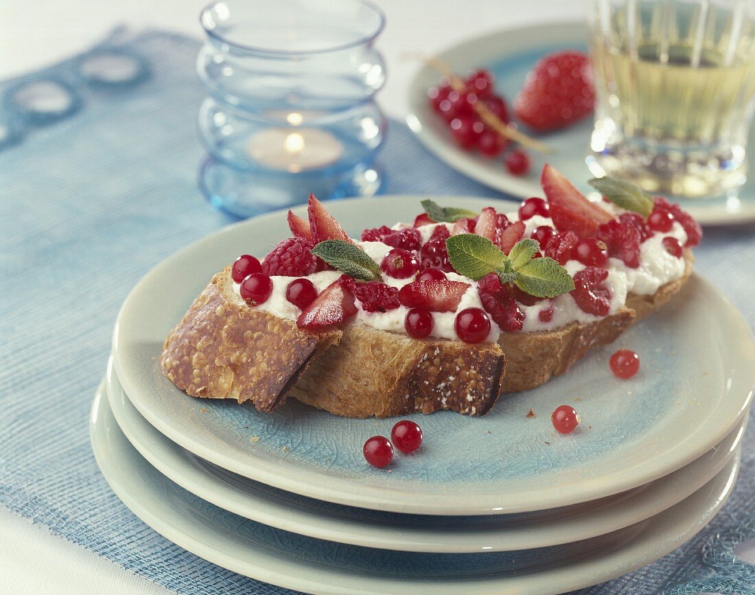 Schlagsahne mit Waldfrüchten und frischer Minze auf Weißbrot