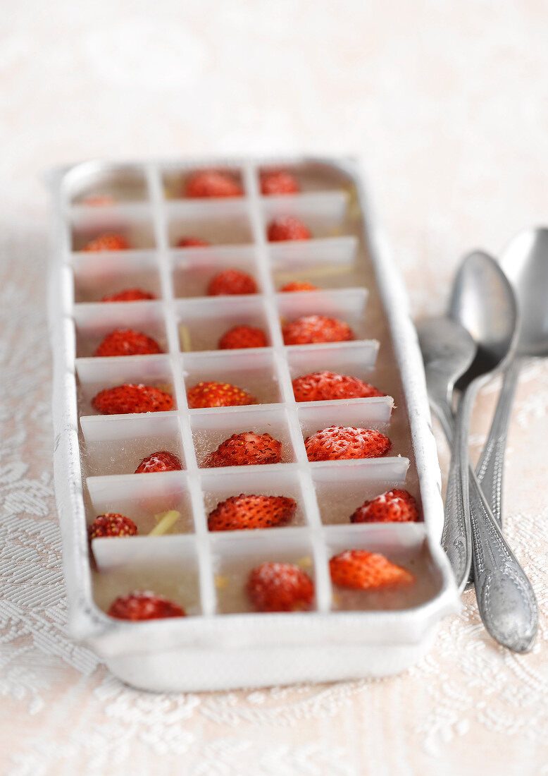 Ice cubes with a wild strawberry in each