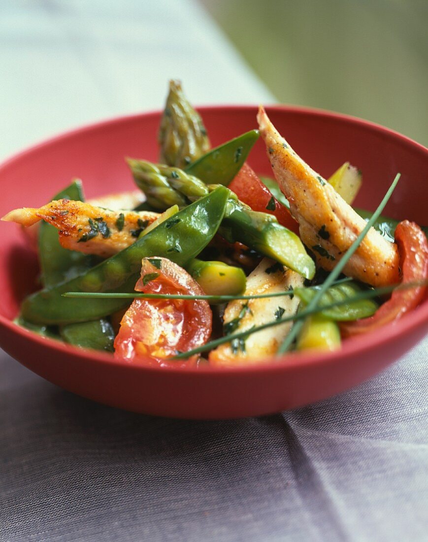 Sliced chicken breast with spring vegetables and herbs