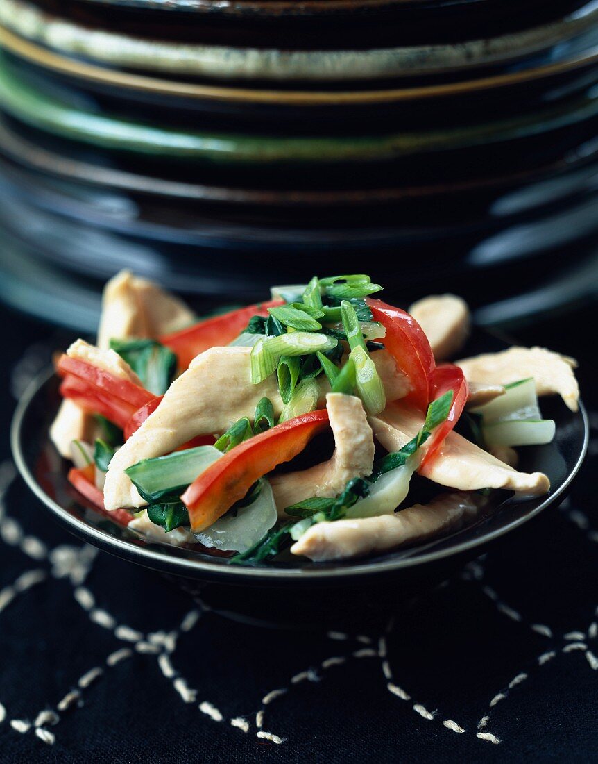 Sliced chicken breasts in cream with red peppers and Bok choy