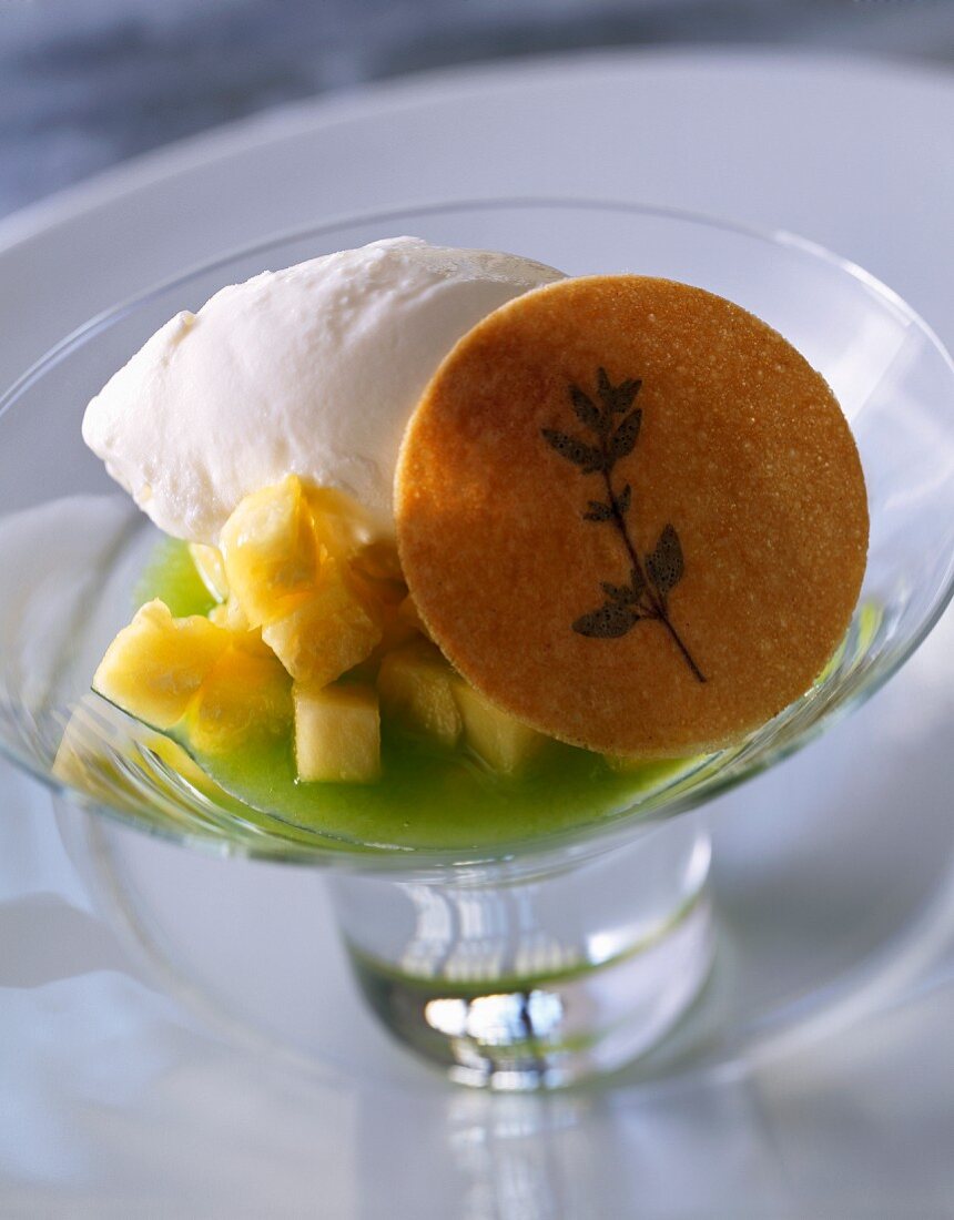 Cream of kiwi soup with diced pineapple, ice cream and thyme cookie