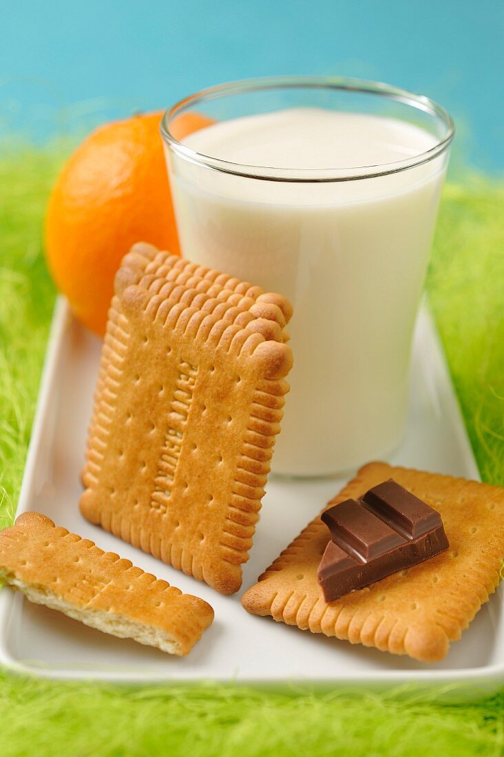 Snack aus Butterkeksen, Milch, Schokolade und Orange