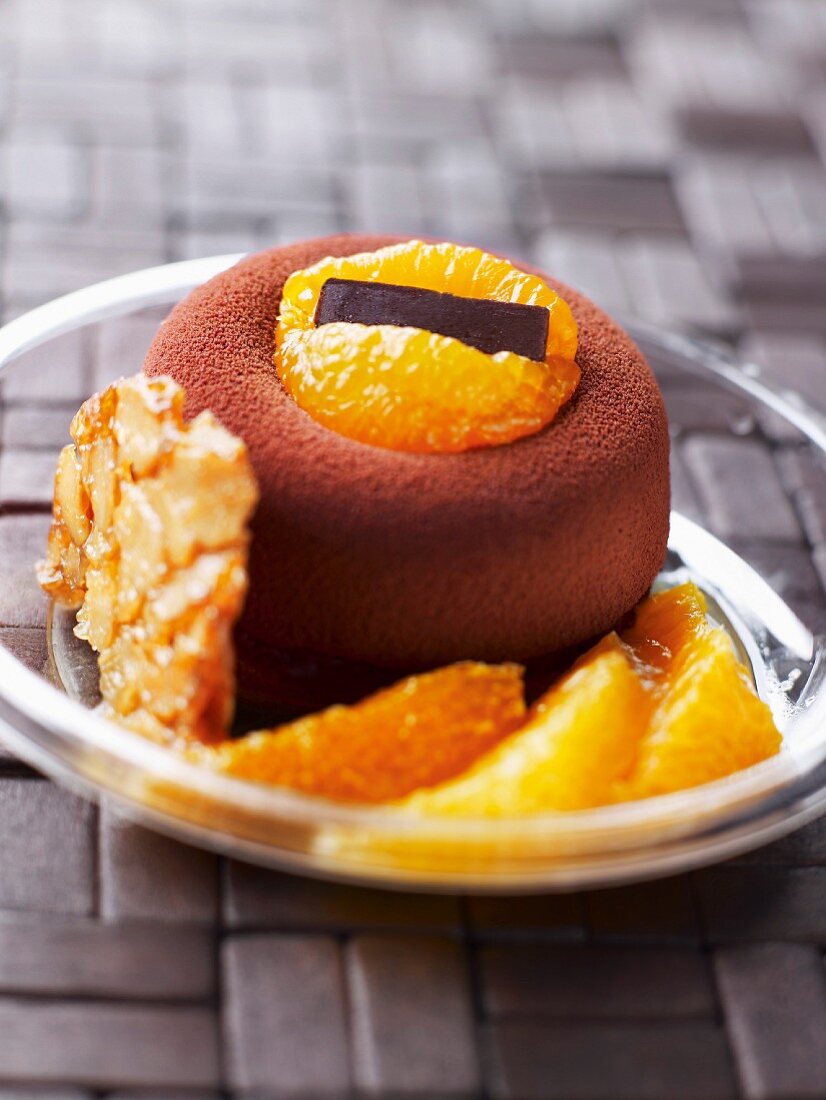 Small round cake coated with cocoa and fresh oranges