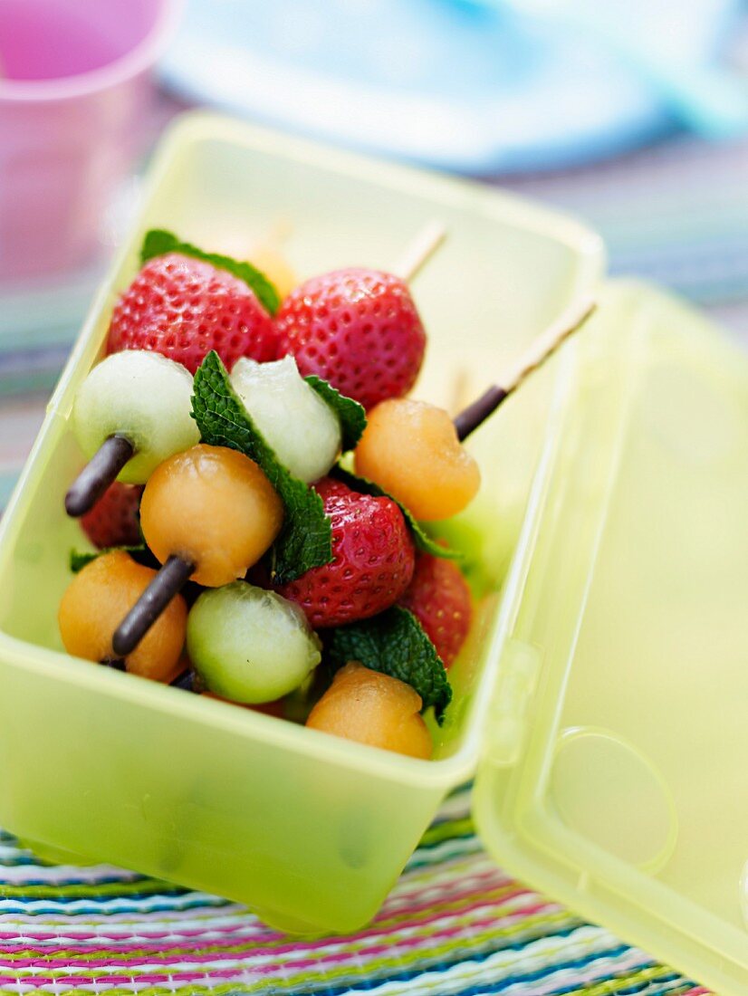 Mini Obstspiesse mit Sommerfrüchten in einer Tupperdose