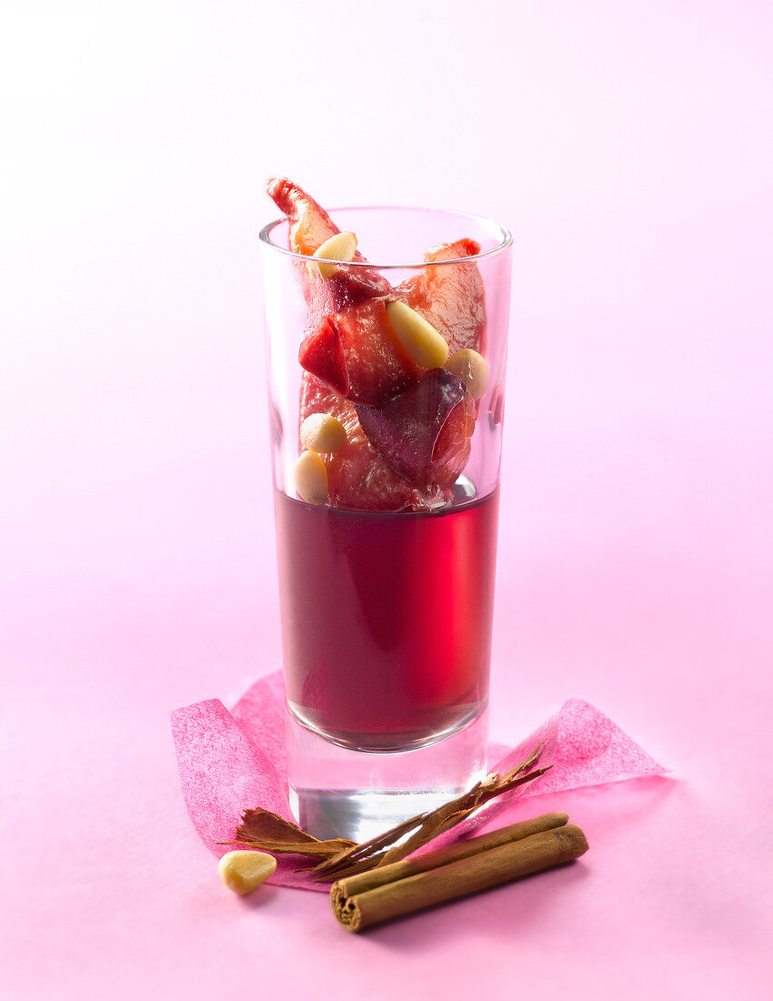 Rotweingelee mit roten Pflaumen, Zimt und Pinienkernen im Glas