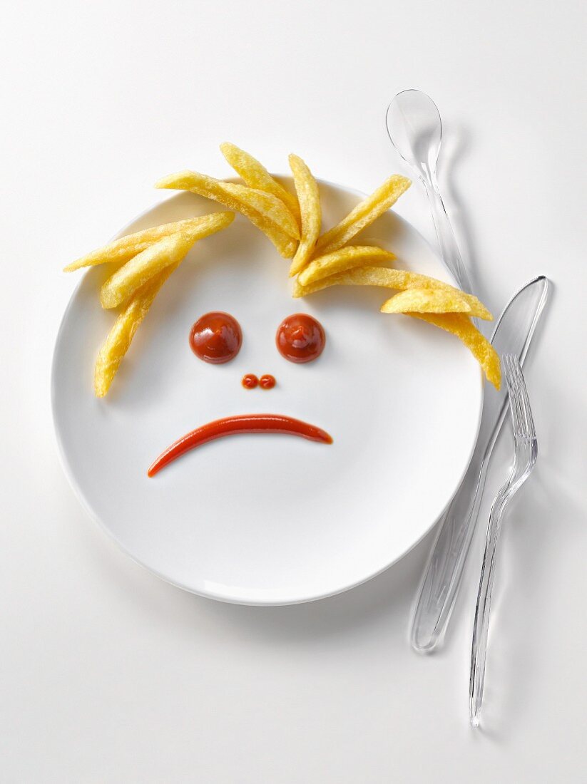 Plate of french fries and ketchup in the shape of a sad face