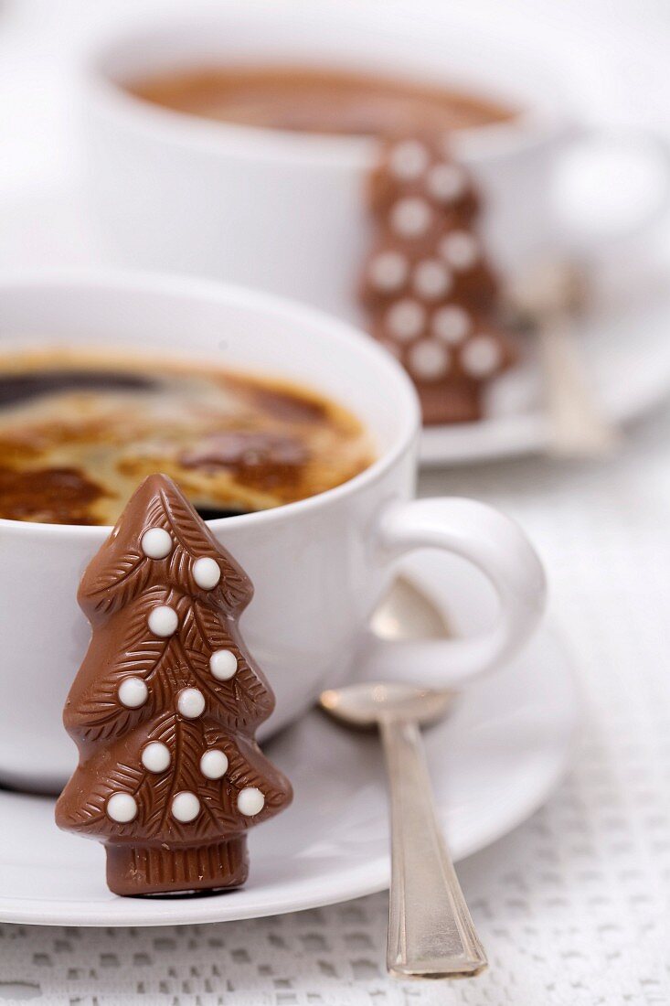 Cup of coffee and Christmas tree-shaped chocolate