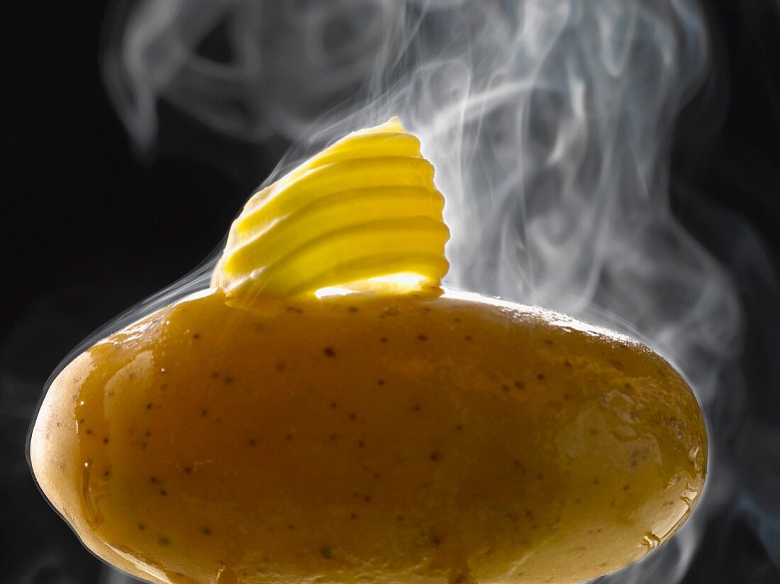 Butterröllchen auf dampfender Kartoffel