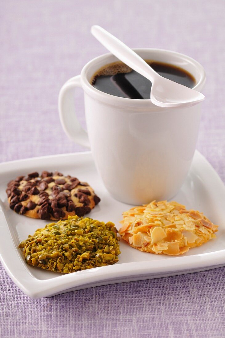 Cup of coffee and three different flavored crunchy cookies