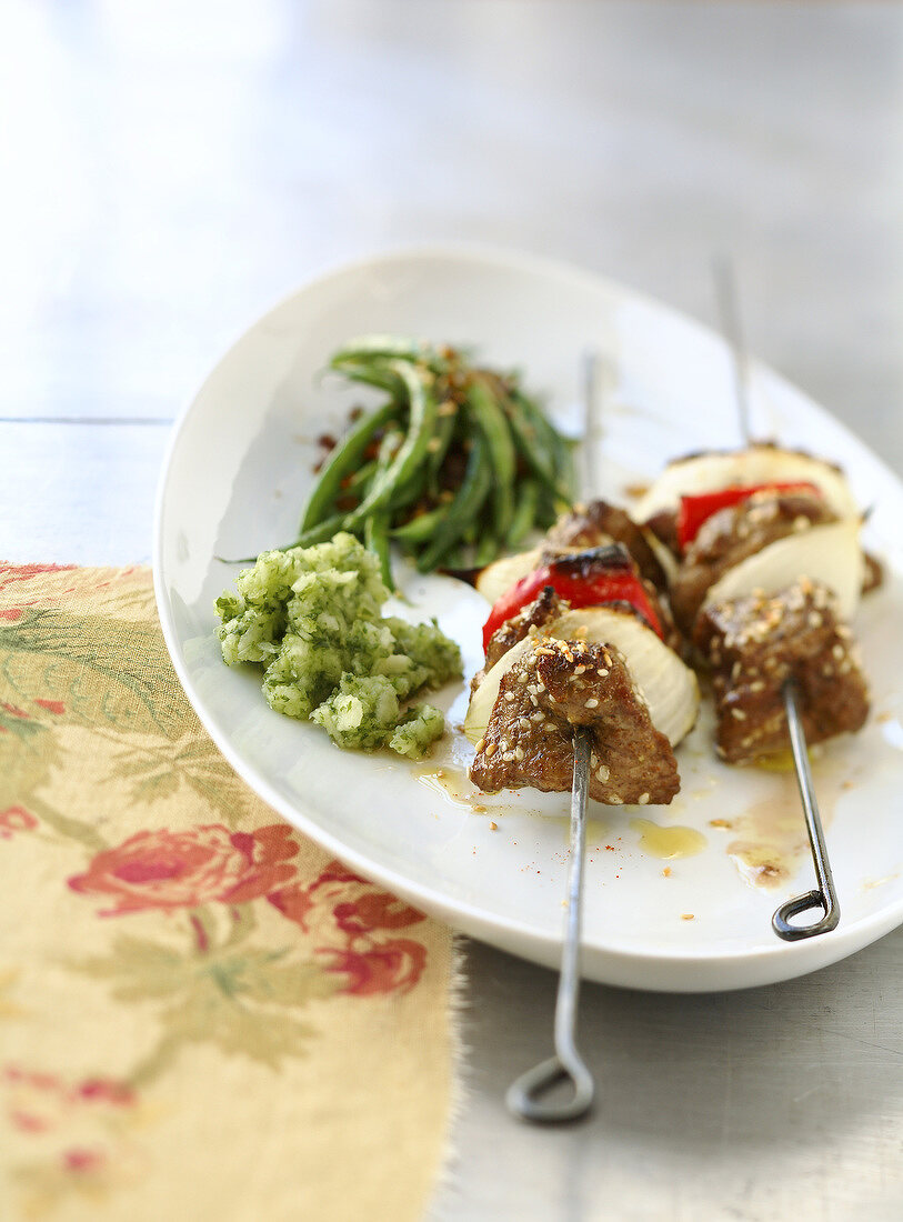 Beef skewers with sesame seeds and green beans